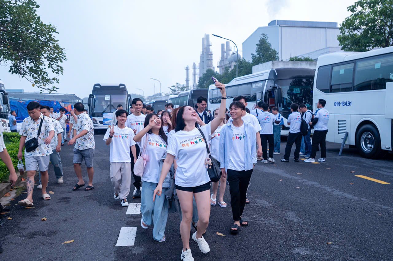 Nhân viên chụp ảnh lưu niệm trước giờ lên xe company trip
